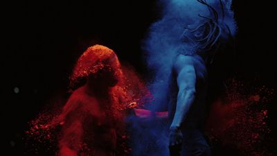 a man and a woman covered in colored powder