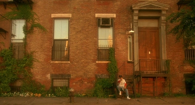 a person sitting on a bench in front of a building