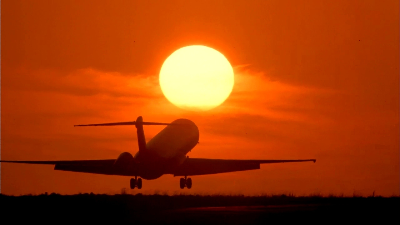 a plane is flying in front of the sun