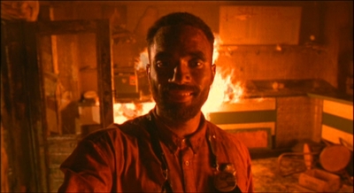 a man standing in front of a fire in a room