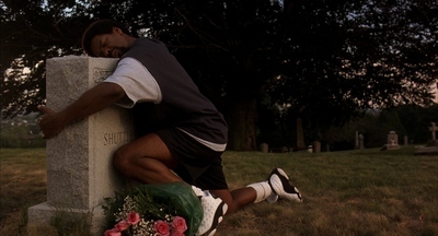 a man sitting on a grave in a cemetery