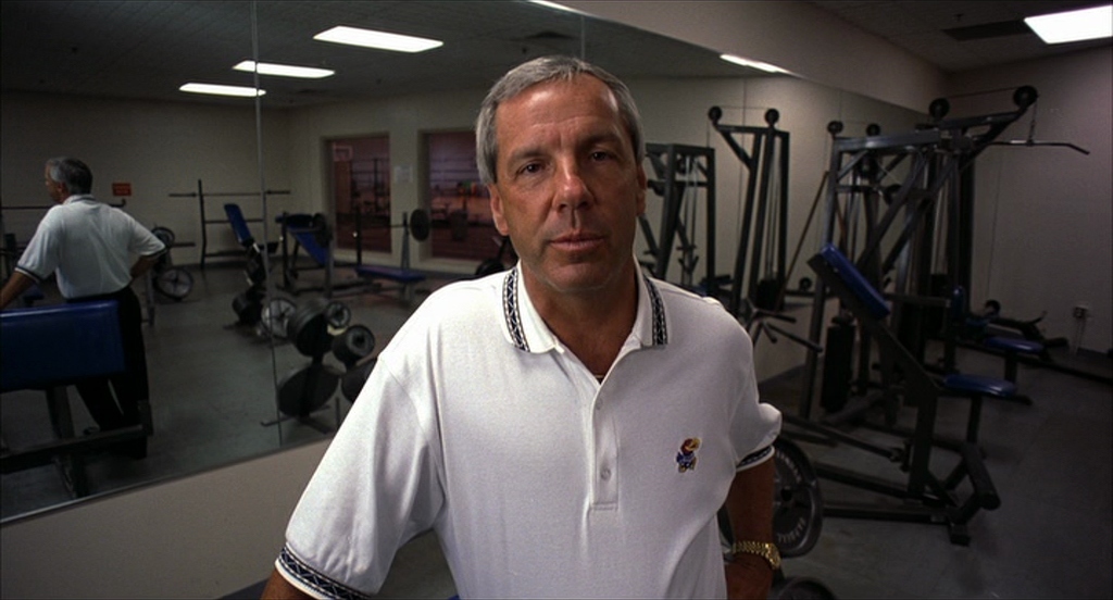 a man standing in a gym looking at the camera