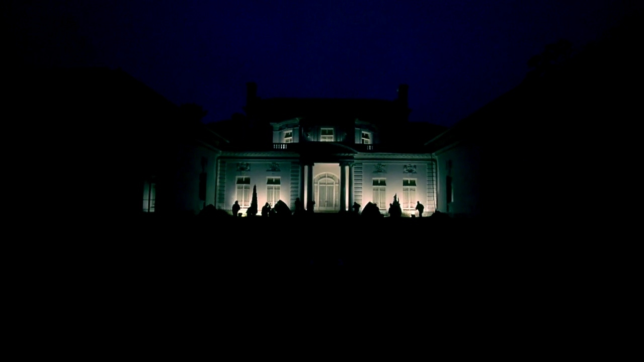 a large white building with people standing in front of it