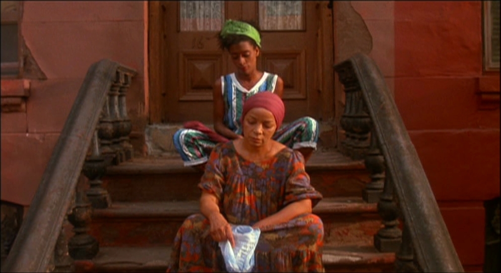 two women sitting on the steps of a building