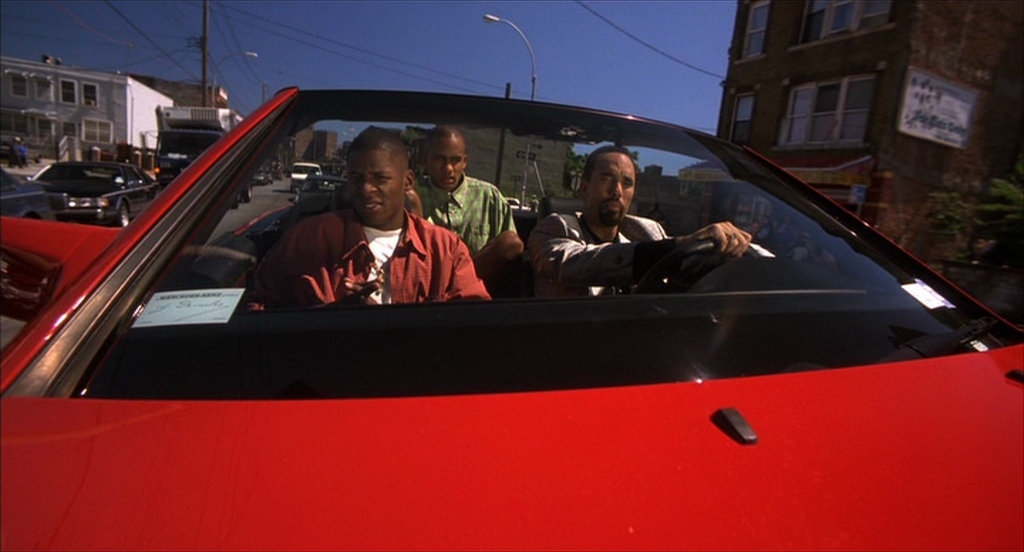 three men are sitting in a red car