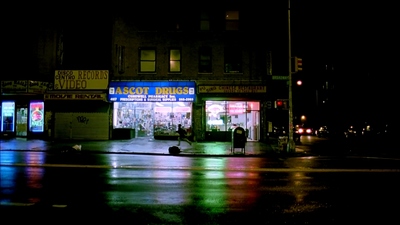 a dark city street at night with a store front lit up