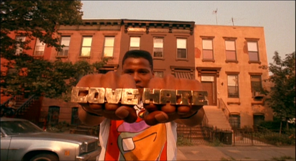 a man holding up a sign that says love in front of a building