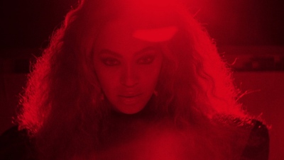 a woman with long hair standing in a dark room