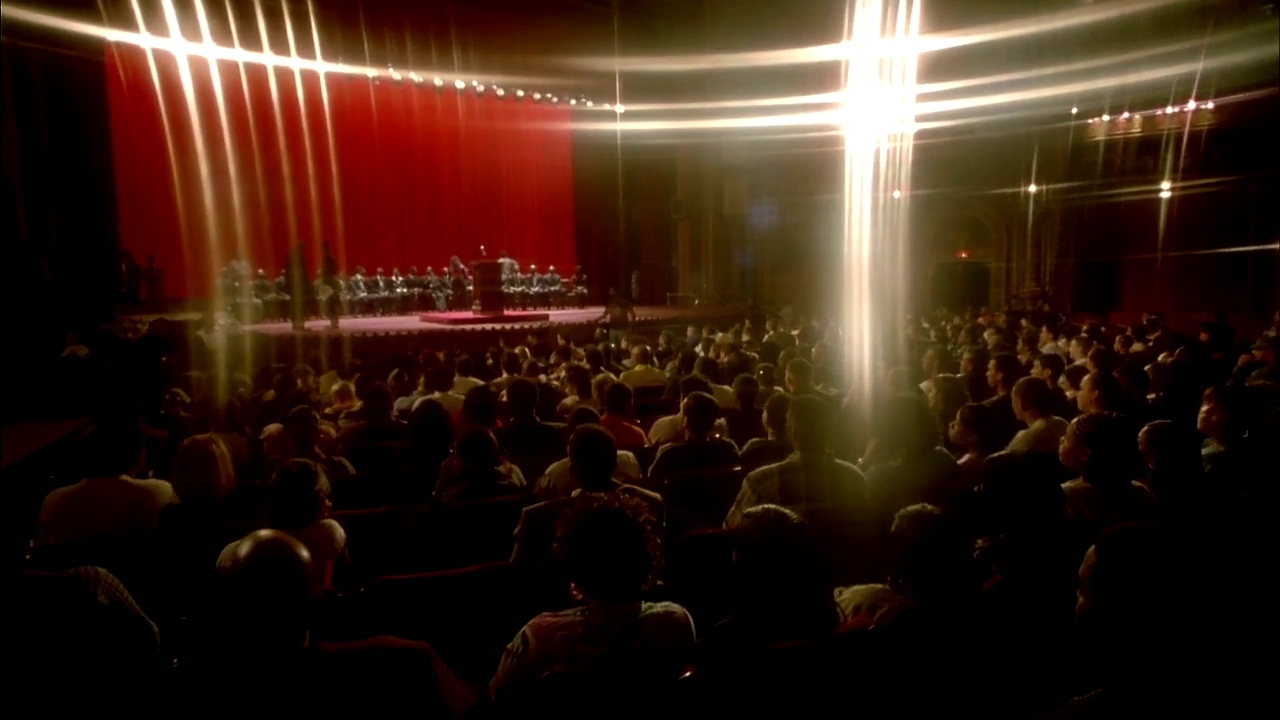 a large group of people sitting in front of a cross