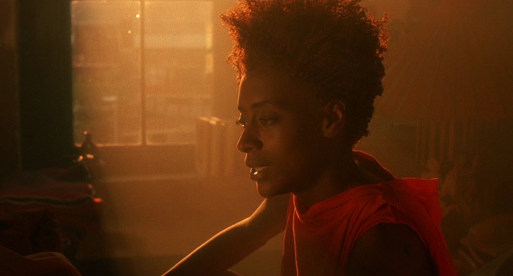 a woman in a red vest sitting in front of a window