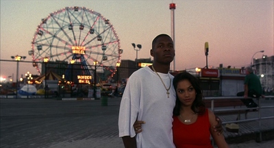 a man and a woman standing in front of a ferris wheel