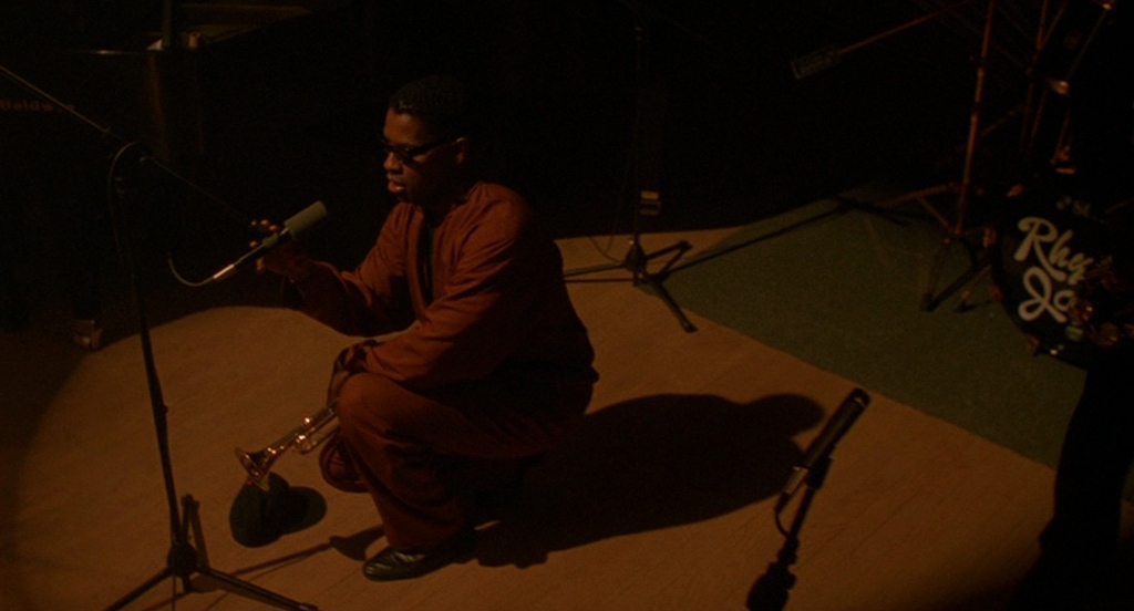 a man sitting on a stage with a microphone