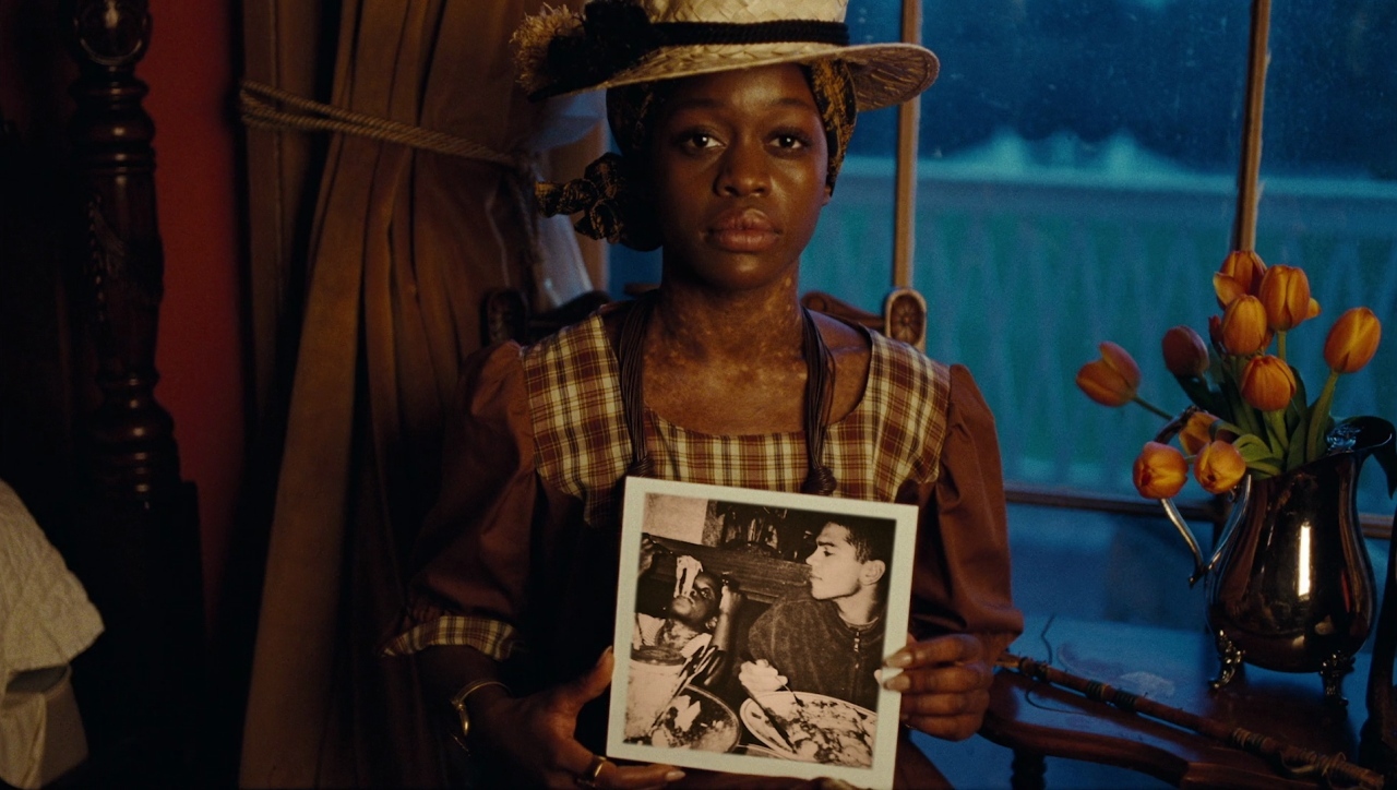 a woman holding a picture of herself in front of a window