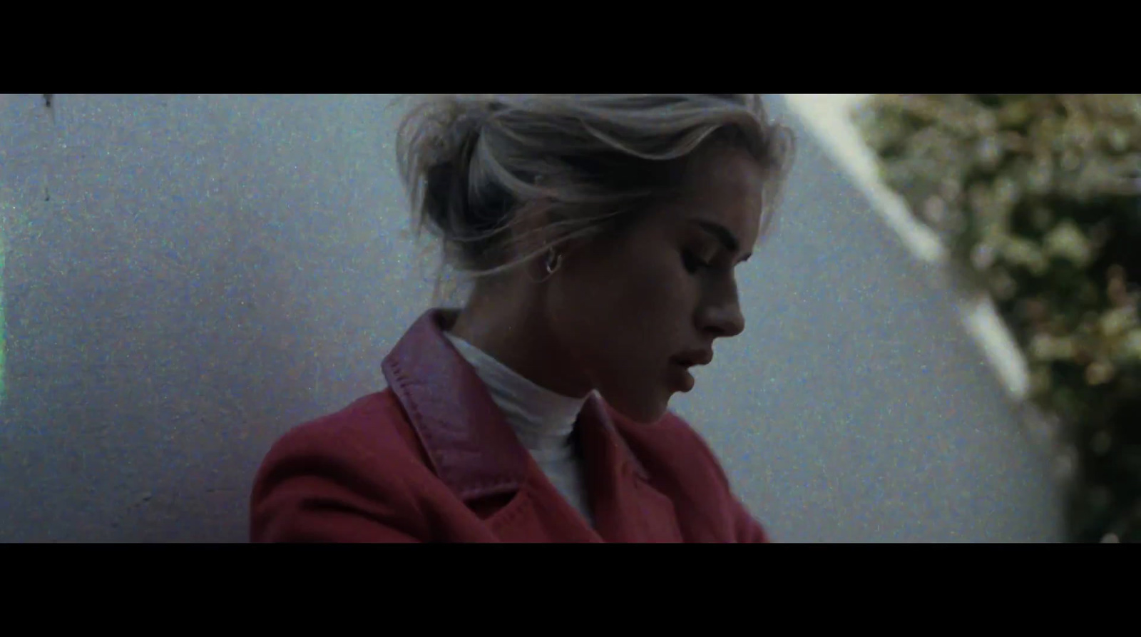 a woman in a red jacket is looking down