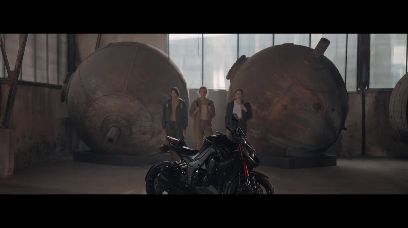 a motorcycle parked inside of a warehouse next to large barrels