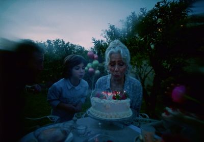 a woman blowing out candles on a cake