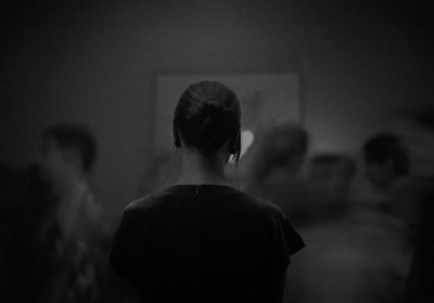 a woman standing in front of a mirror in a dark room