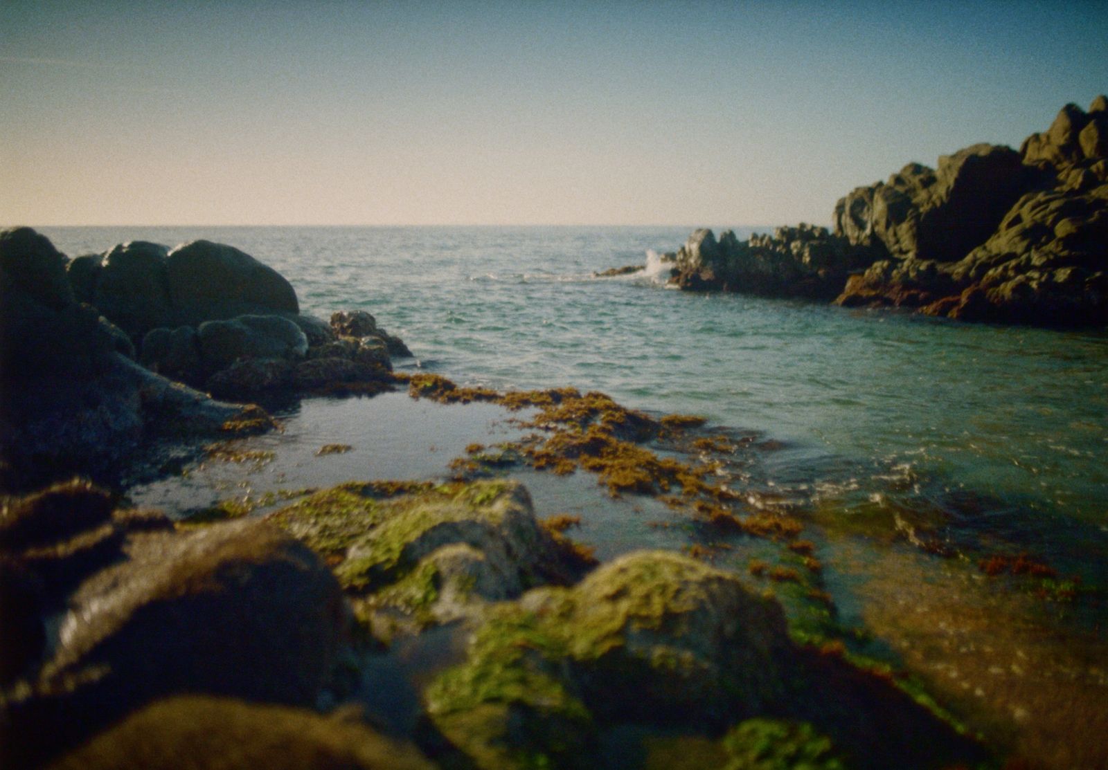 a body of water next to a rocky shore