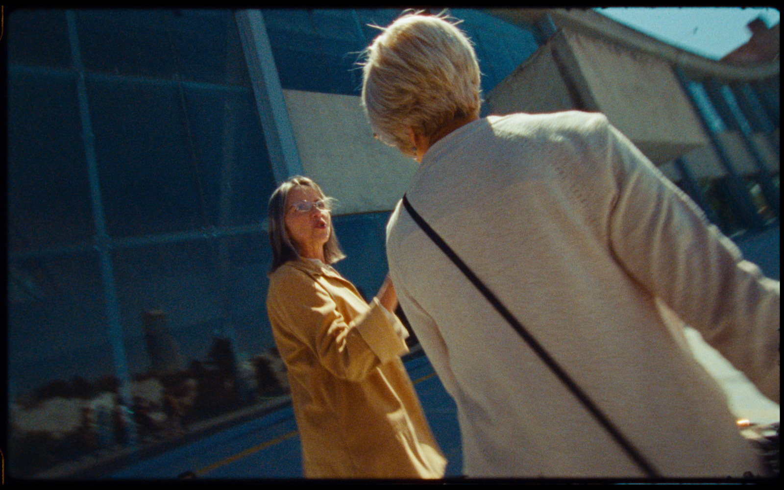 a woman standing next to a man in front of a building