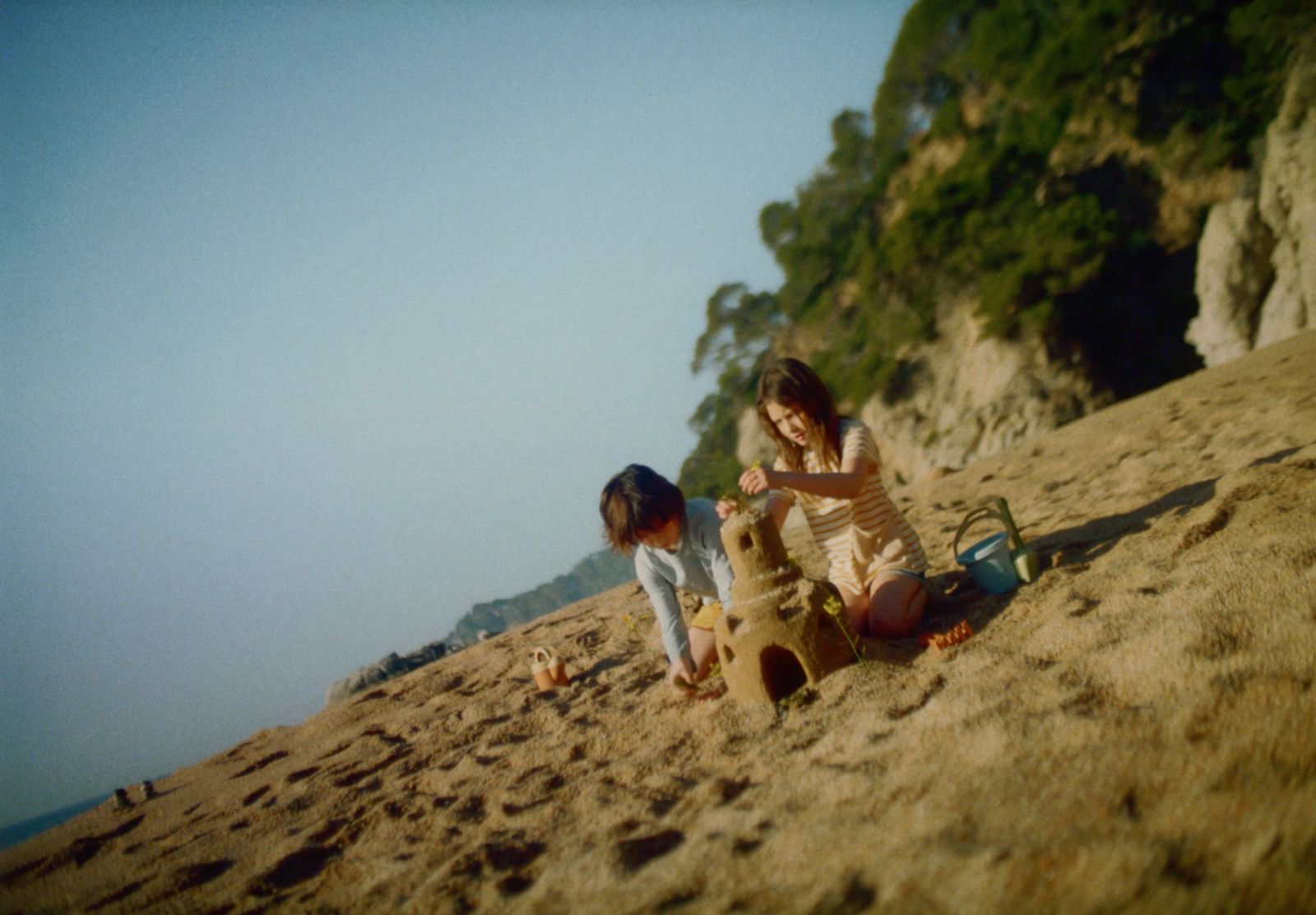 a couple of kids playing on a beach