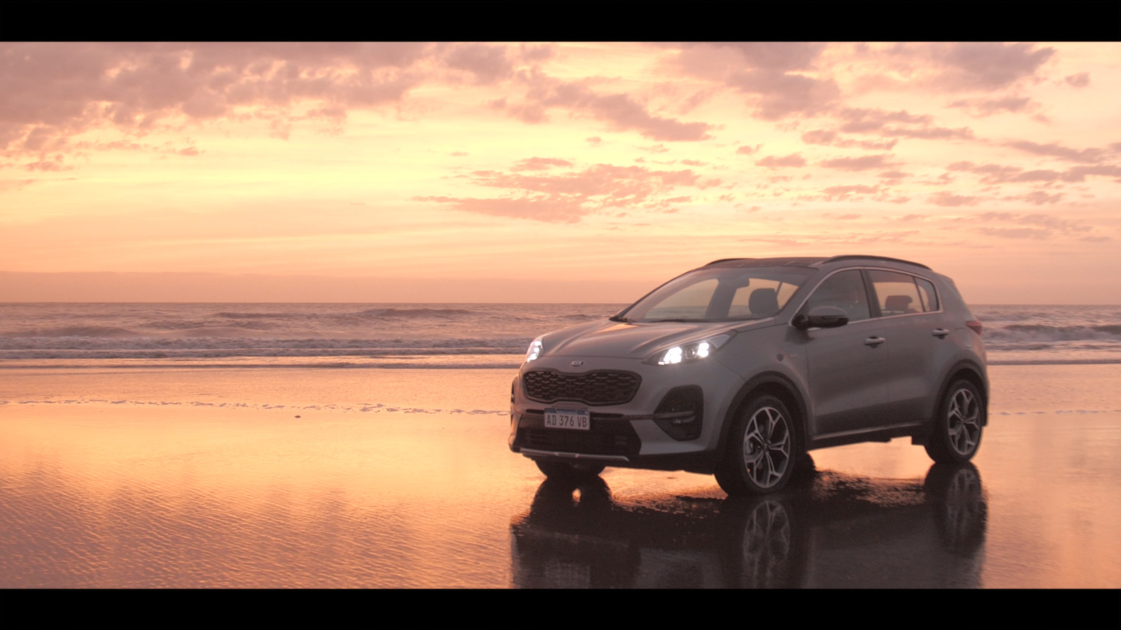 a car parked on the beach at sunset