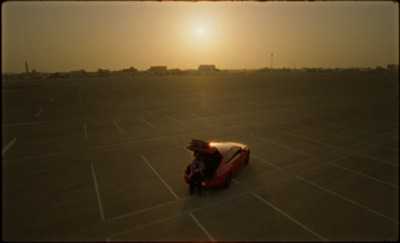 a person sitting on top of a car in a parking lot