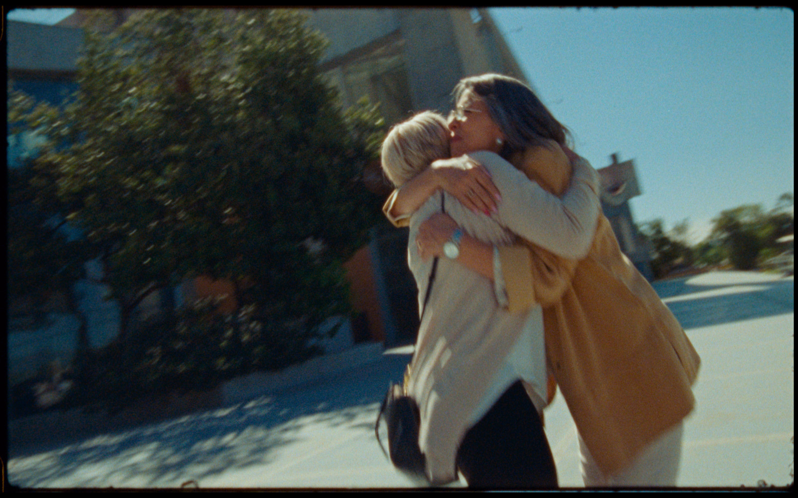 a couple of women hugging each other on a street