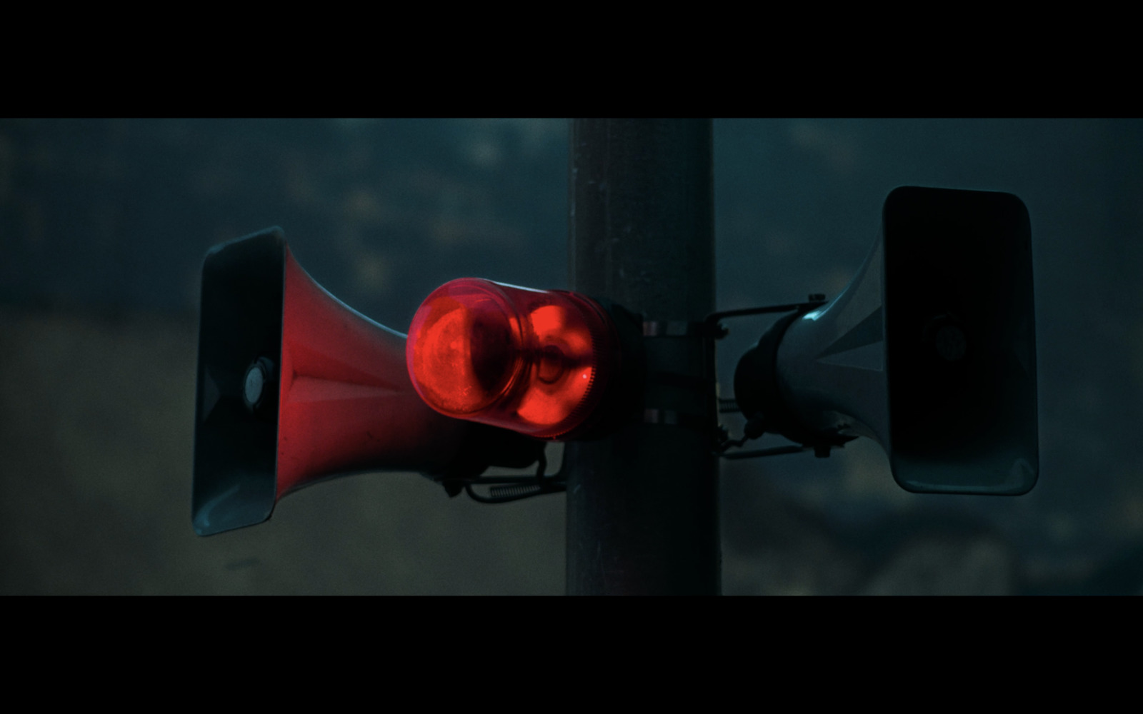 a red traffic light sitting on top of a metal pole