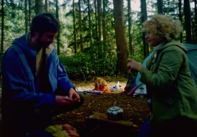 a man and a woman camping in the woods