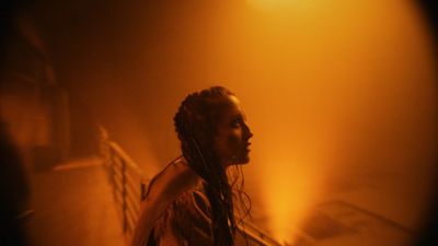 a woman standing in front of a yellow light