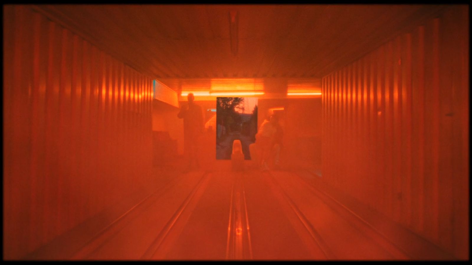 a man is standing in a red tunnel