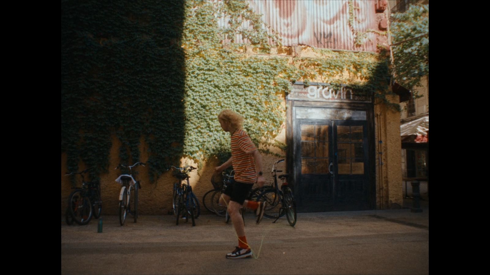 a man walking down a street next to parked bikes