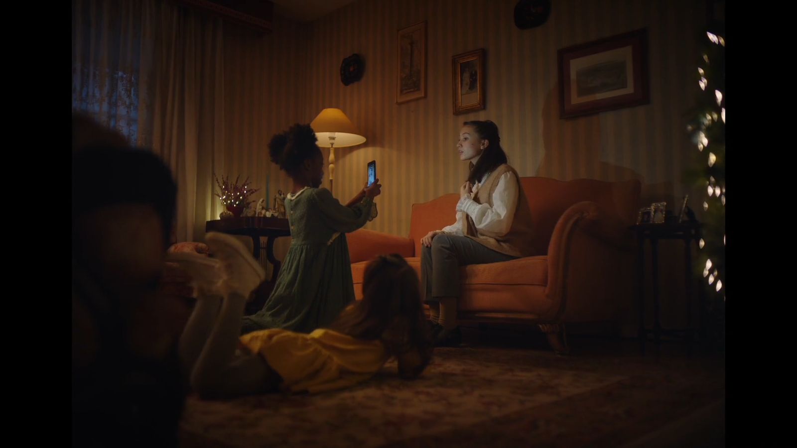 a woman sitting on a couch while holding a cell phone