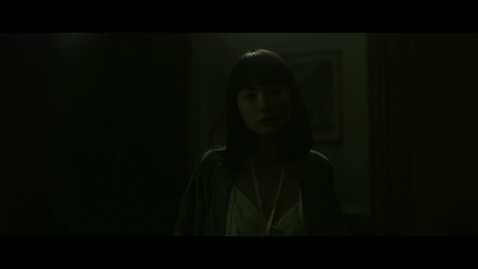 a woman standing in a dark room in the dark