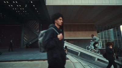 a man walking down a street next to a building