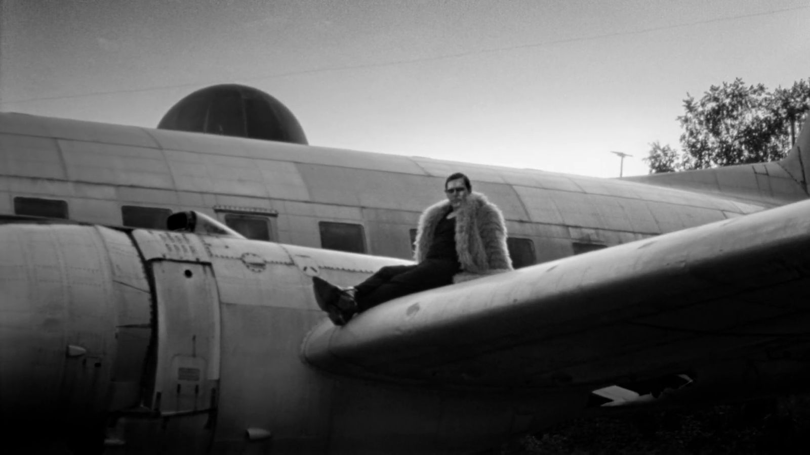 a man sitting on the nose of an airplane