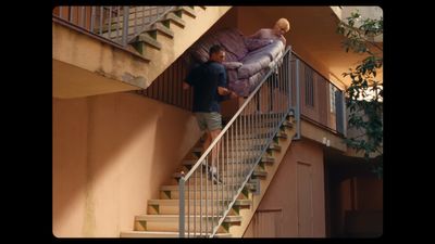 a man standing on a stair case next to a purple couch