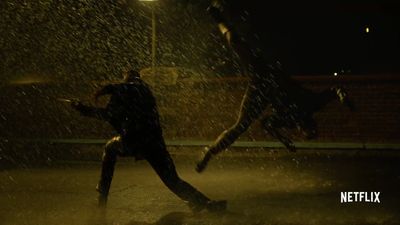 two people running in the rain at night