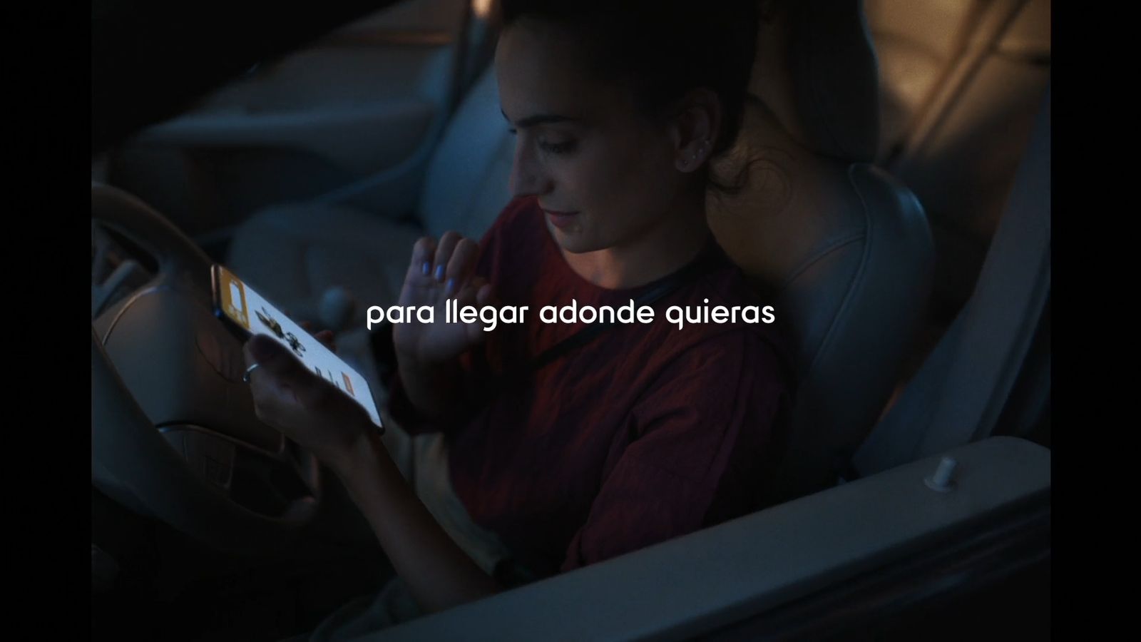 a woman sitting in a car seat looking at a tablet