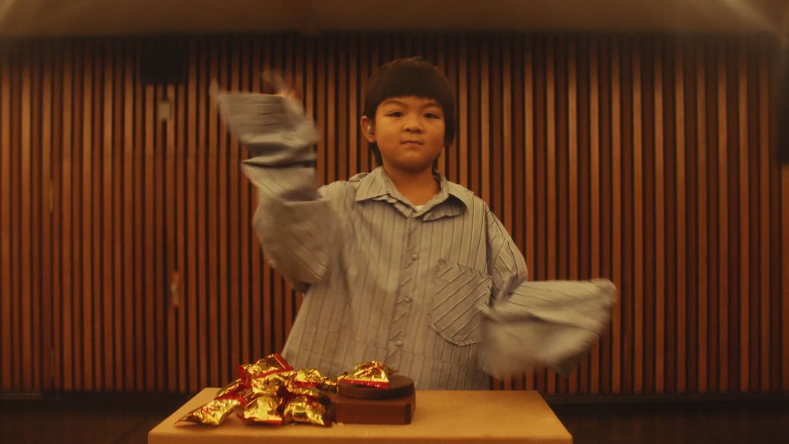 a young boy standing in front of a box of chocolates