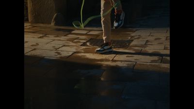 a person standing on a sidewalk with a green hose