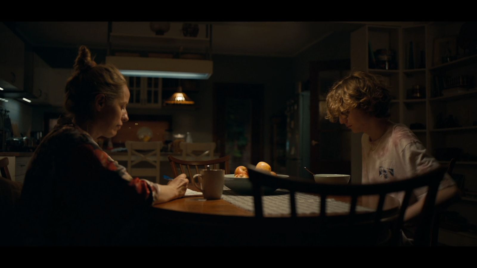 two people sitting at a table in a dark room