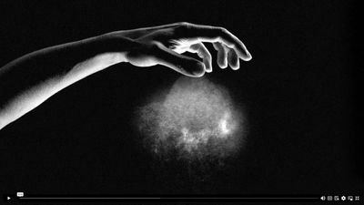 a black and white photo of a person's hand reaching for something