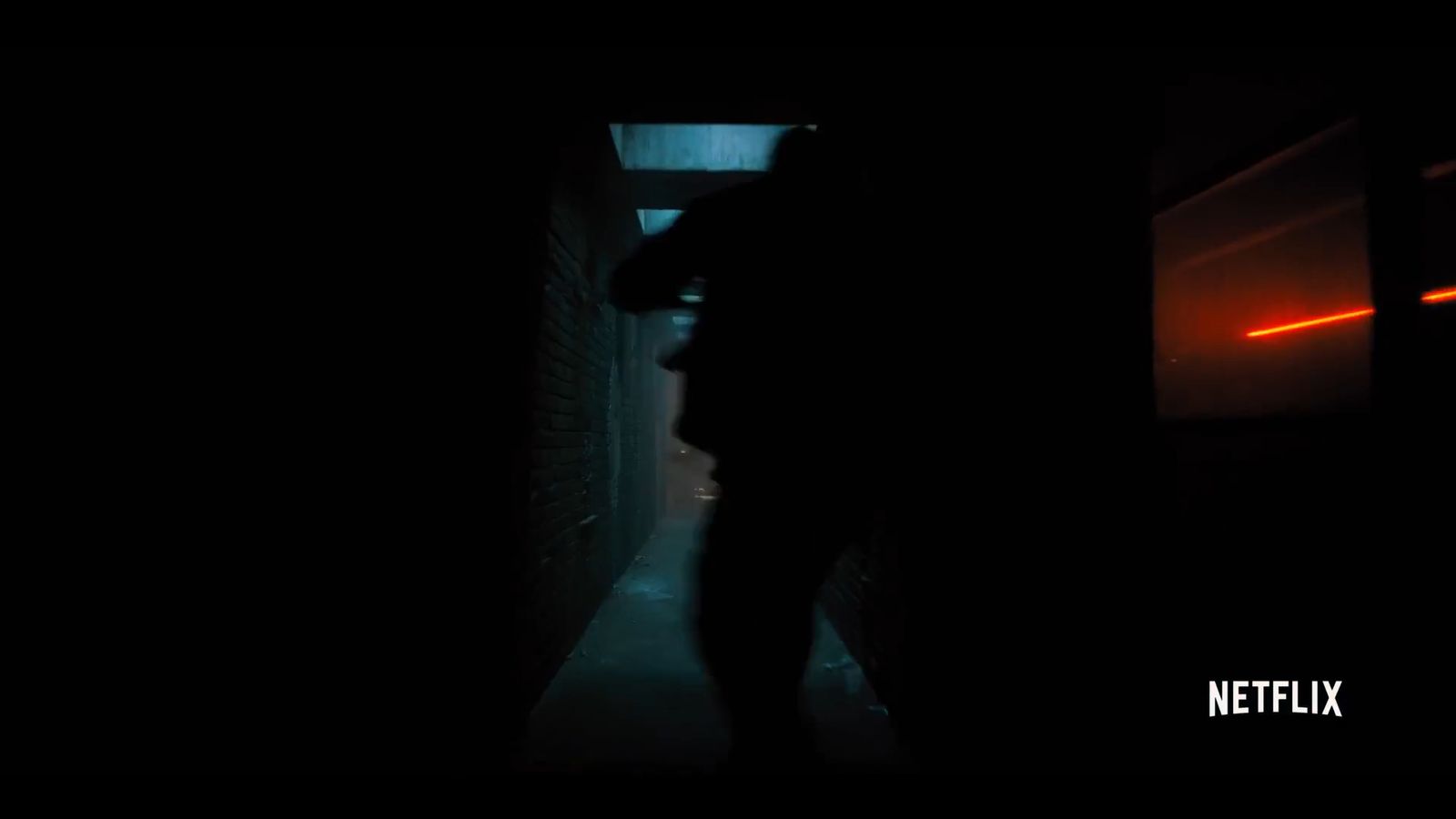 a person standing in a dark hallway at night