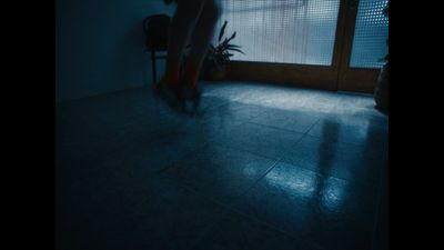 a person standing on a tiled floor in a dark room