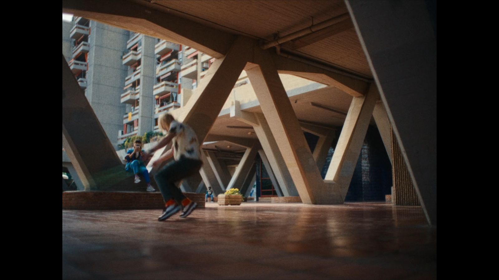 a man riding a skateboard down a street next to tall buildings