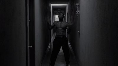 a man standing in a hallway with his shirt off