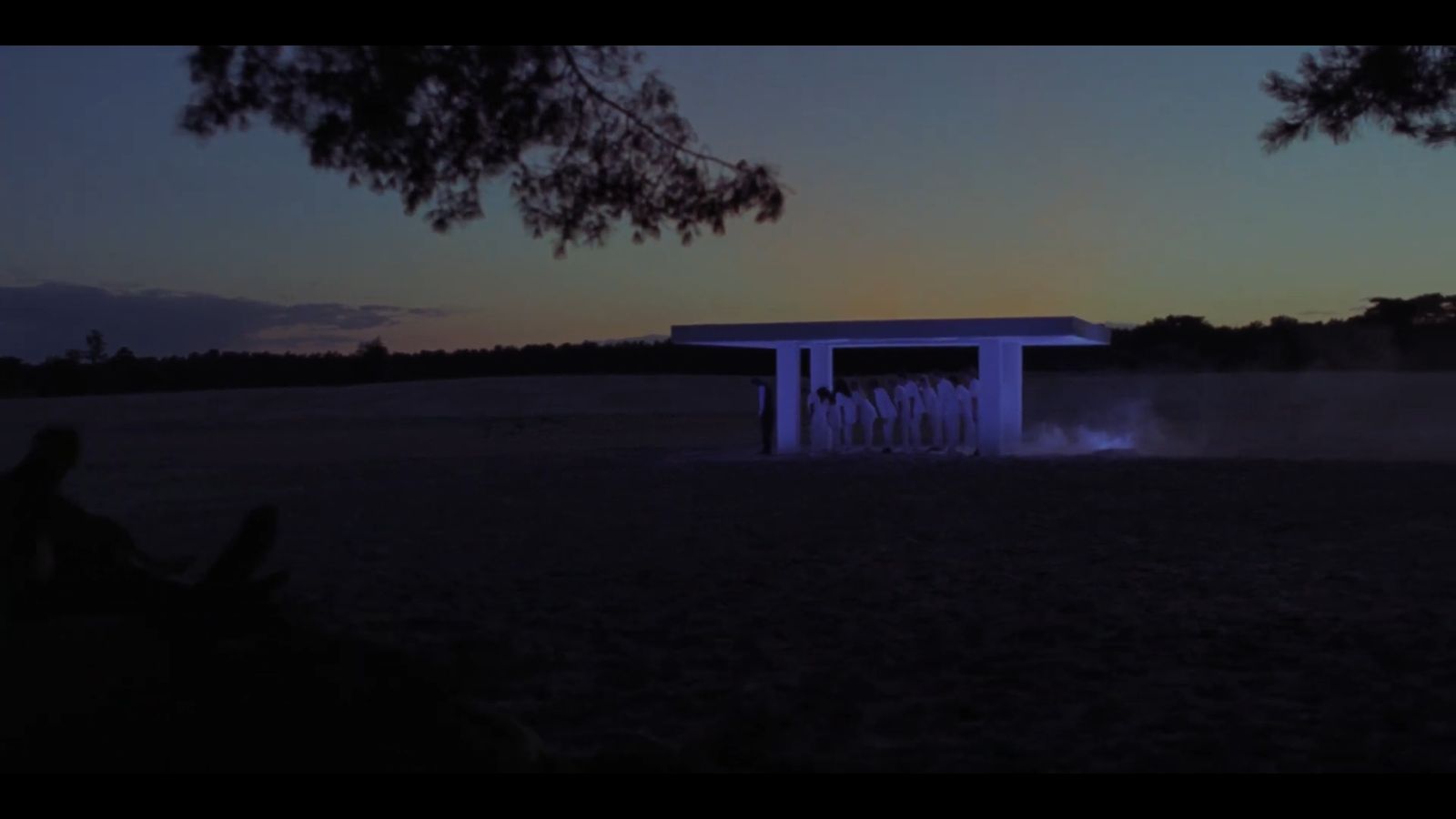 a group of people standing in front of a blue structure