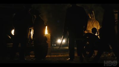 a group of people standing around a motorcycle at night