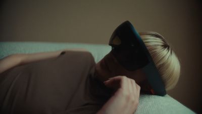 a woman laying on top of a couch wearing a blindfold